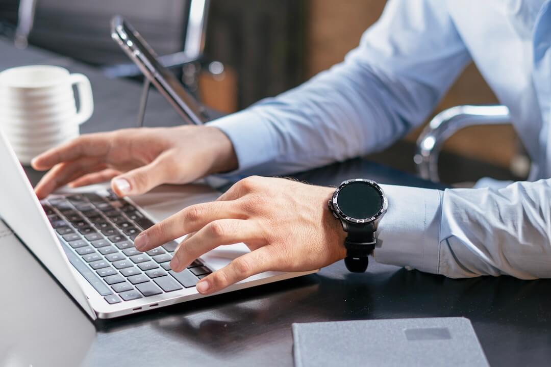 A person typing on a laptop, focused on protecting intellectual property and managing information overload.